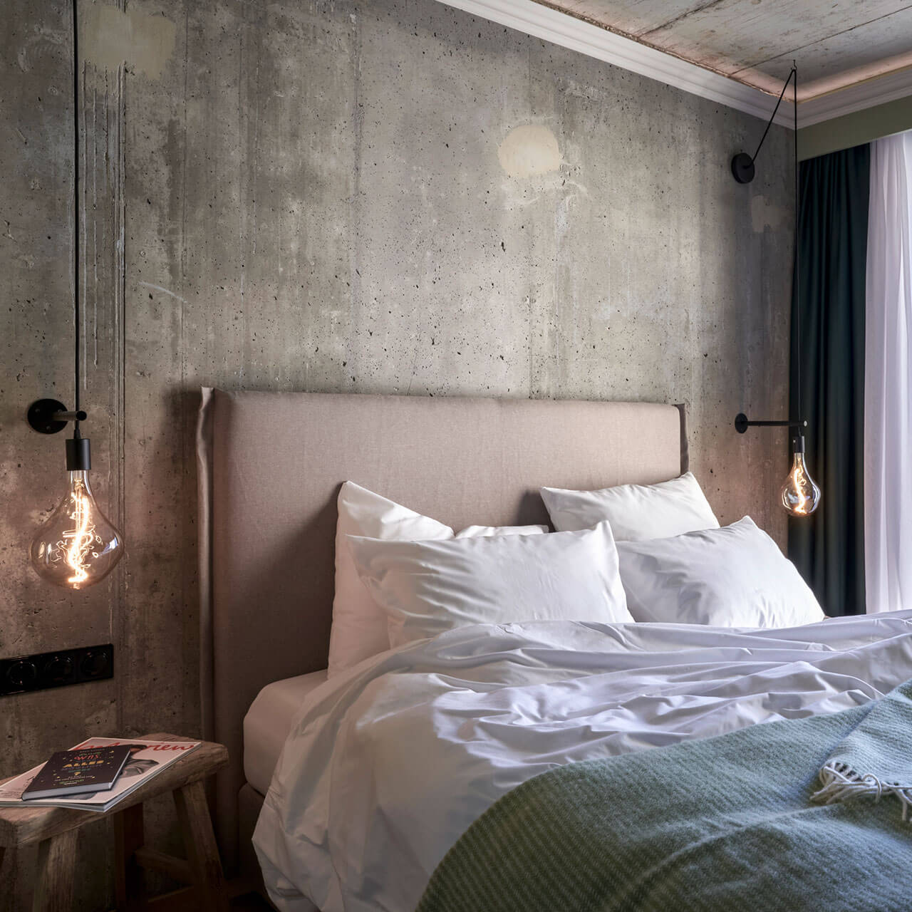 cozy bed, urban concrete walls and warm lights